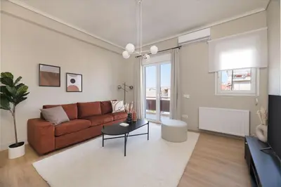 a living room with a brown couch and a table at Beaming 2BR Apartment in Paleo Faliro by UPSTREET in Athens