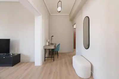 a living room with a table and a chair at Beaming 2BR Apartment in Paleo Faliro by UPSTREET in Athens