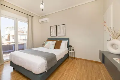 a bedroom with a bed and a large window at Beaming 2BR Apartment in Paleo Faliro by UPSTREET in Athens