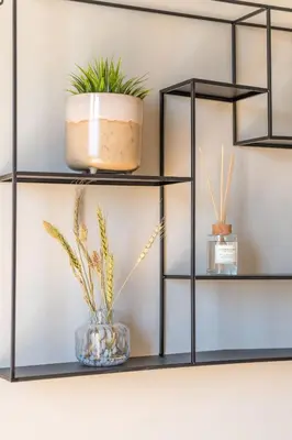 a black shelf with plants on it at Beaming 2BR Apartment in Paleo Faliro by UPSTREET in Athens