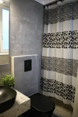 a bathroom with a sink and a shower curtain at Gargaretta Suites Wildflower 1 Acropolis Museum District in Athens