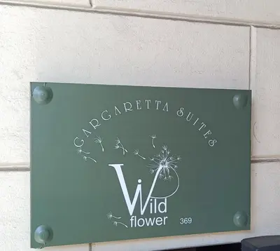 a sign for a wild flower on a wall at Gargaretta Suites Wildflower 1 Acropolis Museum District in Athens