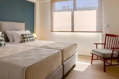 a bedroom with a bed and a chair and a window at Athome Athens Luxury Flat in Athens