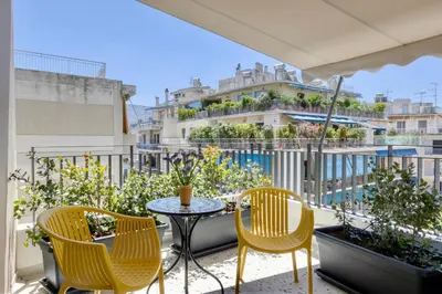 a balcony with a table and chairs and a building at Athome Athens Luxury Flat in Athens
