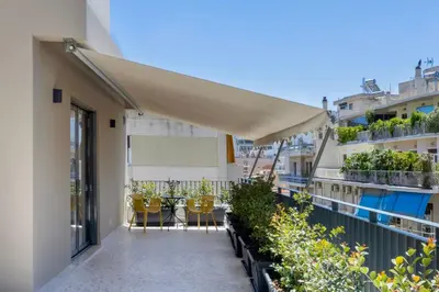 a balcony with chairs and plants on a building at Athome Athens Luxury Flat in Athens