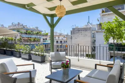 a patio with chairs and a table on a roof at Athome Athens Luxury Flat in Athens