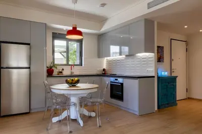 a kitchen with a table and chairs and a refrigerator at Athome Athens Luxury Flat in Athens
