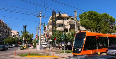 an orange bus is driving down a city street at Glyfada Relax 9 in Athens