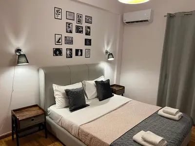 a bedroom with a bed with black and white pillows at Stylish And Comfortable Apartment in Athens