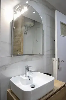 a bathroom with a white sink and a mirror at Stylish And Comfortable Apartment in Athens