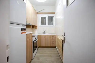 a kitchen with wooden cabinets and a white refrigerator at Stylish And Comfortable Apartment in Athens