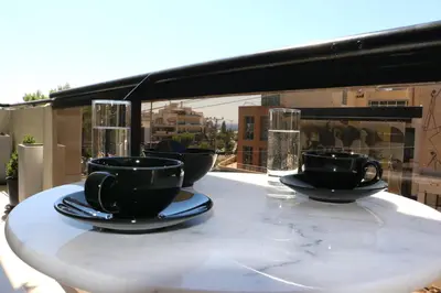 a table with cups and plates and glasses on a balcony at Glyfada Relax 8 in Athens