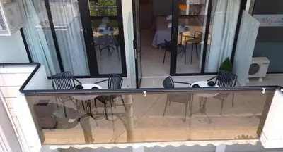 a glass table with chairs on a patio at Glyfada Relax 8 in Athens