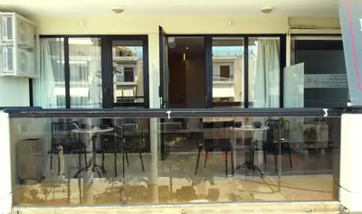 a glass window of a building with a table and chairs at Glyfada Relax 8 in Athens