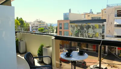 a balcony with a table and chairs on a building at Glyfada Relax 8 in Athens
