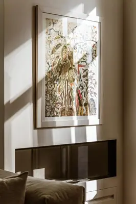 a picture hanging above a couch in a living room at Likno Athens in Athens