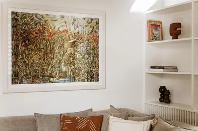 a painting hanging on a wall above a couch at Likno Athens in Athens