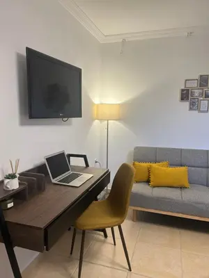 a living room with a desk with a laptop and a couch at Meraki I in Varkiza