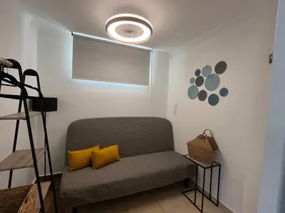 a living room with a couch and a fan at Meraki I in Varkiza