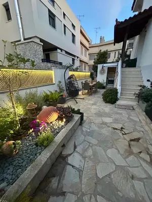 a courtyard of a building with a patio with plants at Meraki I in Varkiza