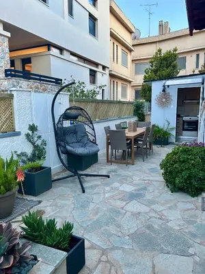 a patio with a chair and a table and some plants at Meraki I in Varkiza