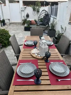 a wooden table with plates and napkins on a patio at Meraki I in Varkiza