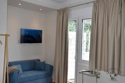 a living room with a blue couch and a window at Gargaretta Suites Wildflower 2 Acropolis Museum District in Athens