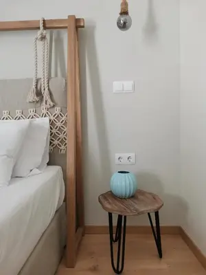 a bedroom with a bed and a table with a vase on it at Gargaretta Suites Wildflower 2 Acropolis Museum District in Athens