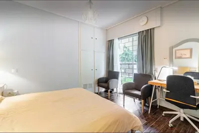 a bedroom with a bed and a desk and chairs at Beach of Falio in Athens