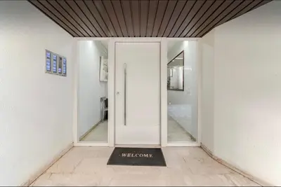 a hallway with a white door and a welcome mat at Beach of Falio in Athens