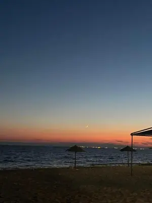 two umbrellas on the beach at sunset at Beach of Falio in Athens