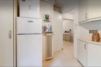 a kitchen with white cabinets and a refrigerator at Beach of Falio in Athens