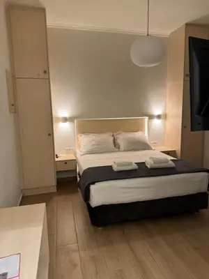 a bedroom with a bed and a flat screen tv at Athinais Inner Suite - historical center in Athens