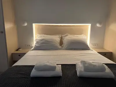 a bed with two pillows and two towels on it at Athinais Inner Suite - historical center in Athens