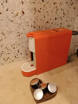 an orange blender sitting on a counter next to some dishes at Athinais Inner Suite - historical center in Athens