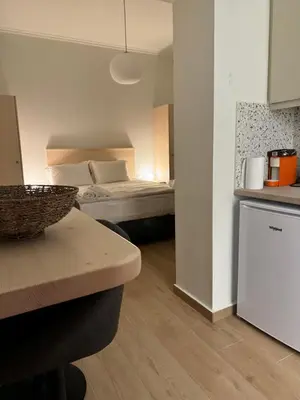 a small room with a bed and a kitchen with a counter at Athinais Inner Suite - historical center in Athens