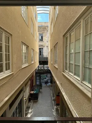 an empty alley between two buildings with windows at Athinais Inner Suite - historical center in Athens