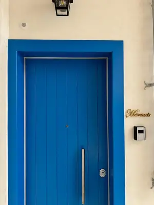 a blue door in a room with a wall at Hermes Central Suite in Athens