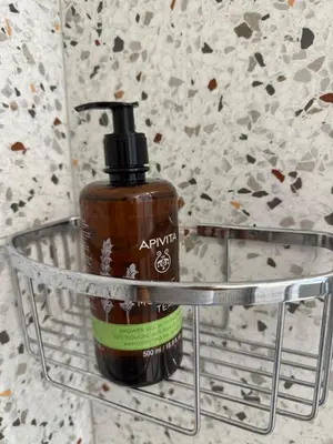a bottle of soap sitting on top of a metal holder at Hermes Central Suite in Athens