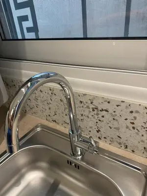 a kitchen sink with a faucet next to a window at Hermes Central Suite in Athens