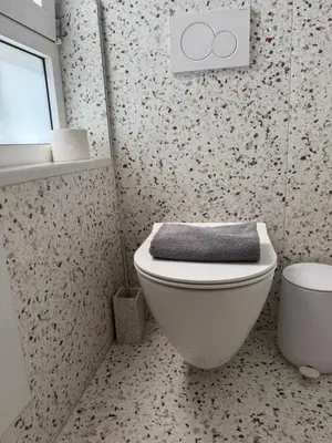 a bathroom with a toilet with a towel on it at Hermes Central Suite in Athens