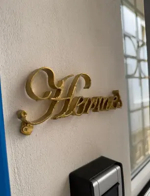 a gold sign on a wall next to a window at Hermes Central Suite in Athens
