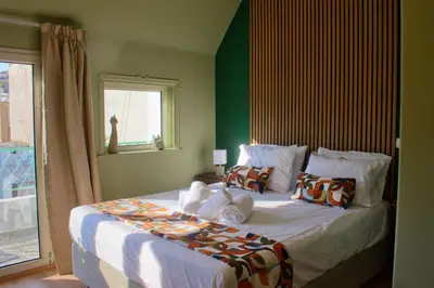 a bedroom with a large bed with a window at Gargaretta Suites Wildflower 3 Acropolis Museum District in Athens