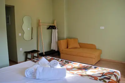 a bedroom with a bed and a couch and towels at Gargaretta Suites Wildflower 3 Acropolis Museum District in Athens