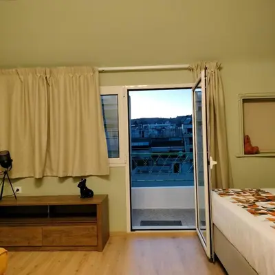 a bedroom with a bed and a sliding glass door at Gargaretta Suites Wildflower 3 Acropolis Museum District in Athens