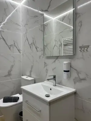 a white bathroom with a sink and a mirror at Central Urban Suite by Zeussuites in Athens