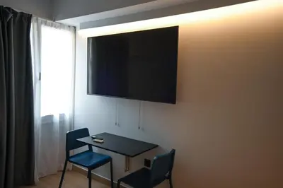 a table and chairs with a television on a wall at Central Urban Suite by Zeussuites in Athens