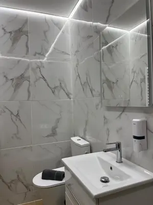 a white bathroom with a sink and a mirror at Central Urban Suite by Zeussuites in Athens