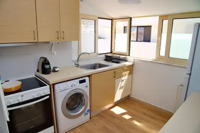 a kitchen with a washing machine and a sink at Glyfada Panoramic view penthouse in Athens