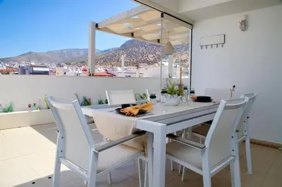 a dining room with a table and white chairs at Glyfada Panoramic view penthouse in Athens